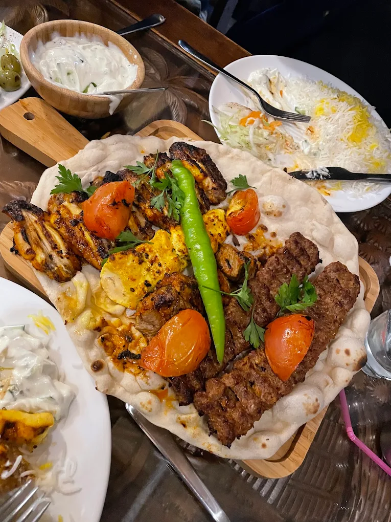 A large sharing platter loaded with Persian grilled meats and peppers.