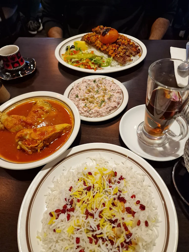 Persian rice garnished with barberries, served with chicken stew and dip at Toranj Restaurant in Edinburgh.